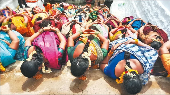 மண்டியிட்டு கைகளை பின்புறமாக கட்டிக்கொண்டு மண் சோறு சாப்பிட்ட பெண்கள்